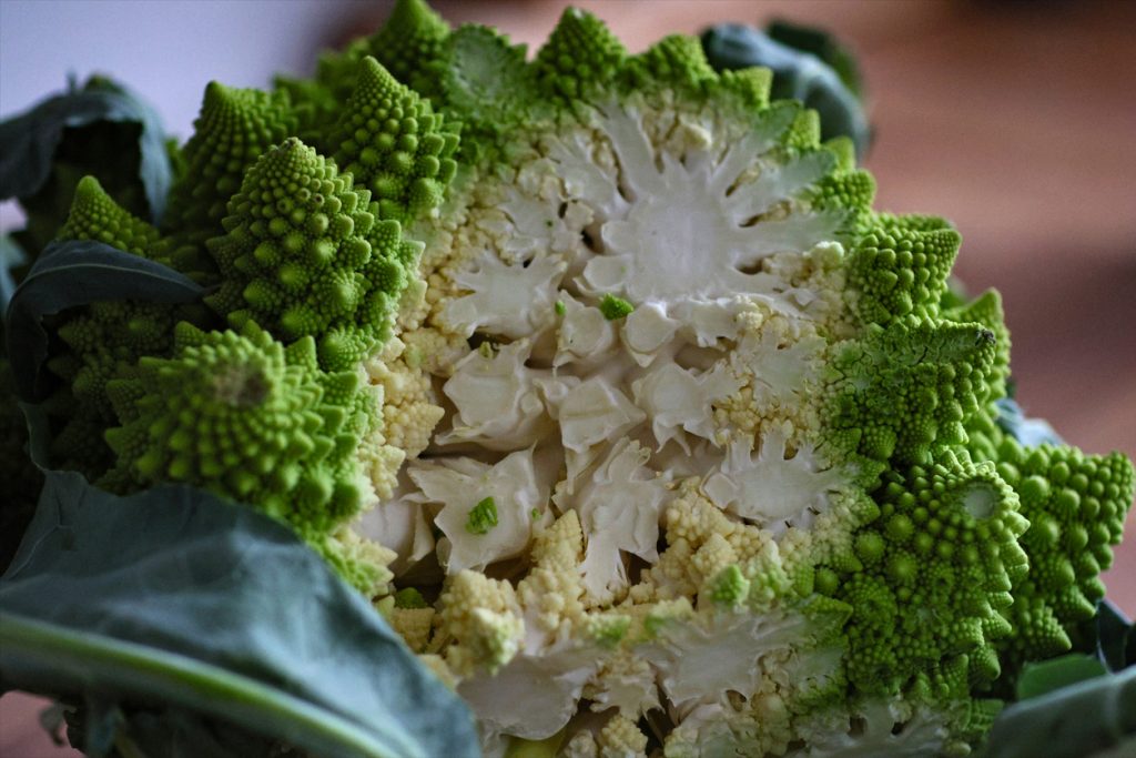 Halbierter Romanesco mit hellgrünen, spiralförmigen Röschen.