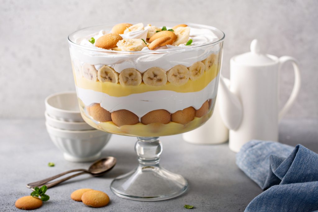 Bananenpudding mit Sahne und Keksschichten ist in einer Dessertschale klar sichtbar aufgeschichtet.