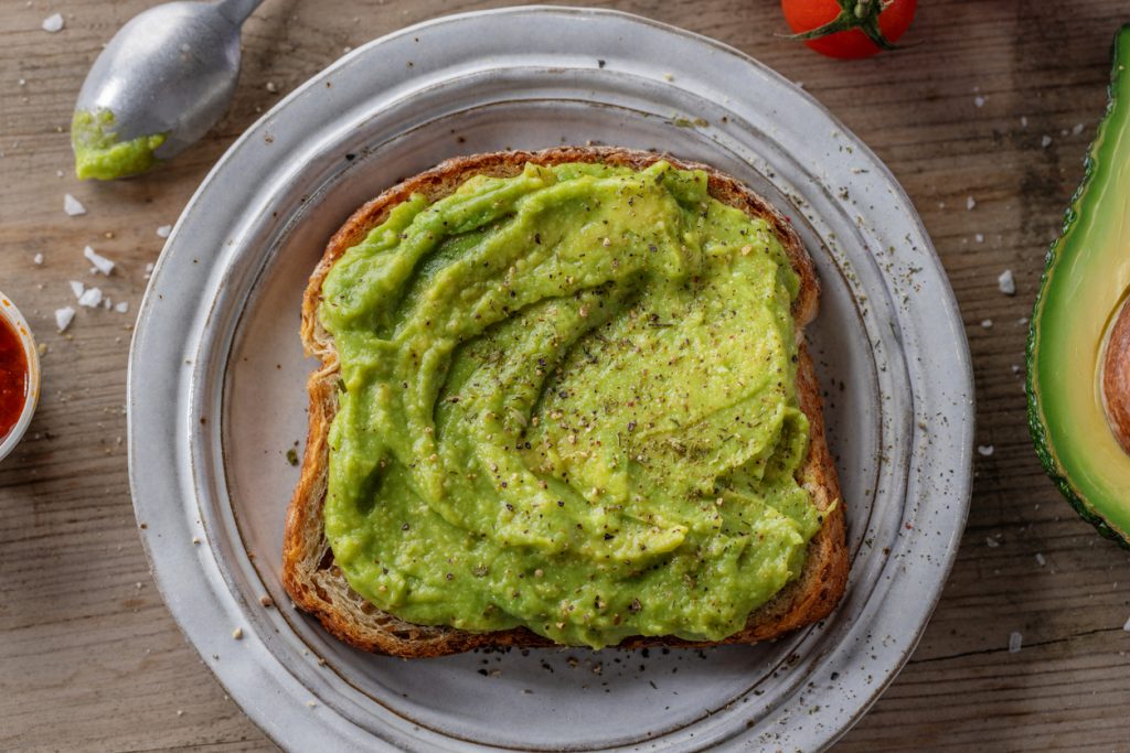 Ein Toast ist dick mit Avocado bestrichen und mit Pfeffer bestreut.