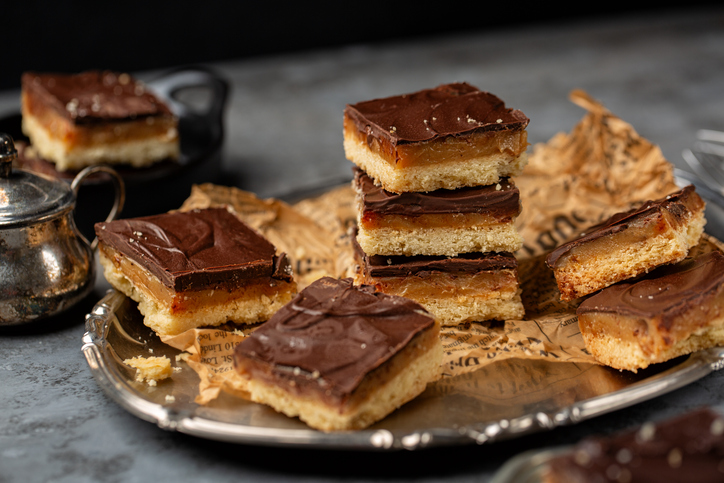 Mehrere Stücke Karamell Shortbread liegen auf einer Platte, einige davon sind gestapelt angerichtet.