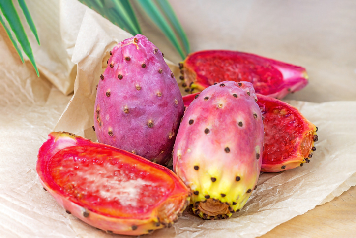 Ganze und halbierte rosa Kaktusfeigen mit rotem Fruchtfleisch
