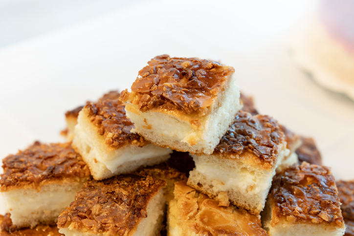 Mehrere Bienenstich-Schnitten mit heller Cremefüllung und gerösteter Mandelkruste