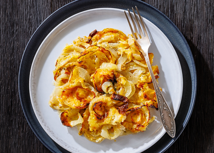 Portion Tennessee-Zwiebelauflauf mit Käse und gebräunten Zwiebeln auf einem Teller