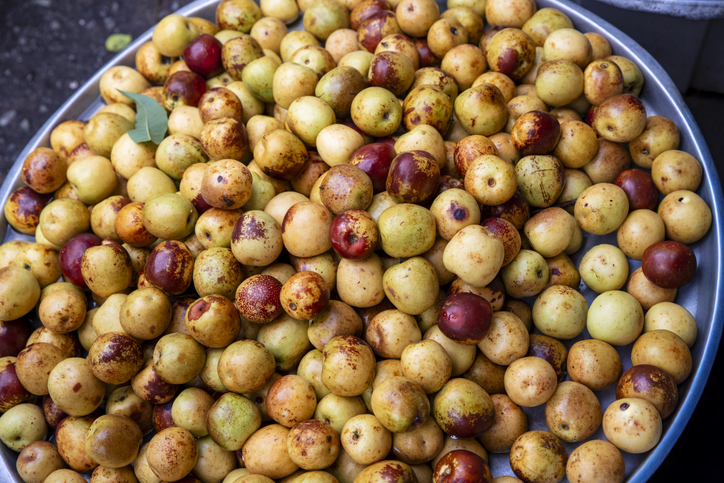 Gelbgrüne und rotbraune Jujube-Früchte auf einem großen Tablett