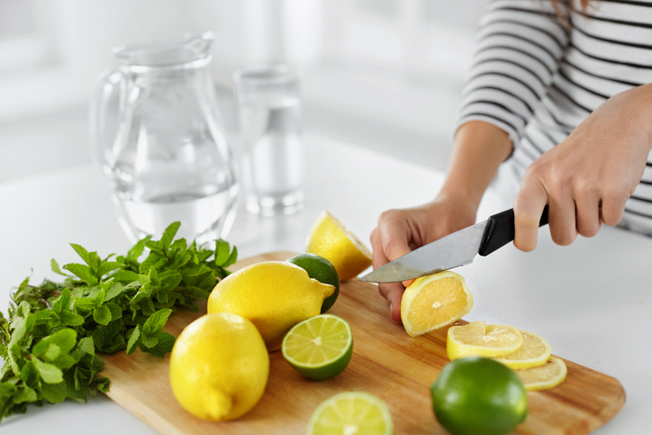 Zubereitung von Detox-Sommerwasser mit Zitronen, Limetten und frischer Minze