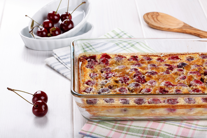 Goldbraunes Kirschclafoutis mit vielen Kirschen in einer rechteckigen Auflaufform