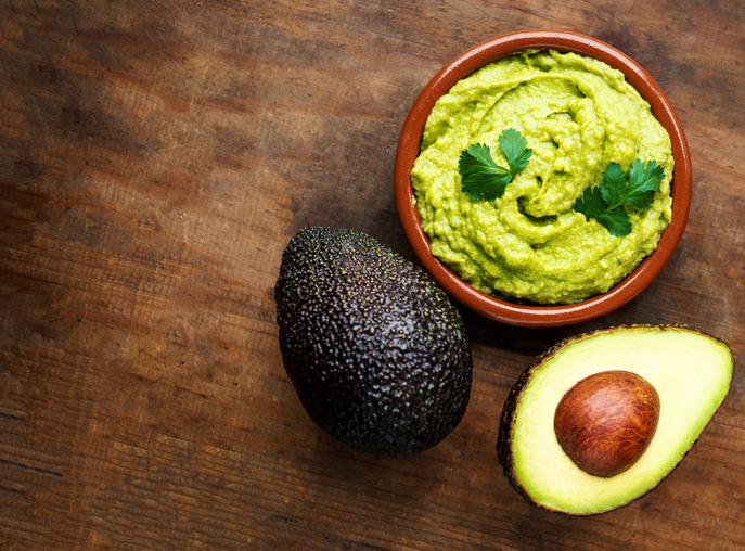 Cremige Guacamole aus Avocado mit Limette, Kräutern und Gewürzen in einer Schale.
