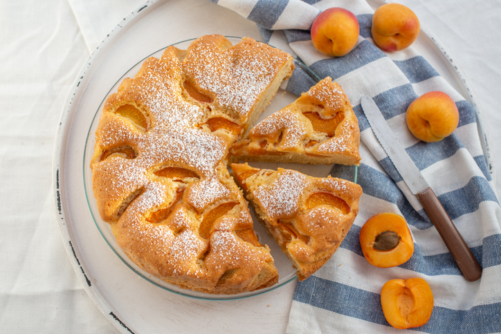 Frisch gebackener Aprikosenkuchen mit Aprikosenstücken und Puderzucker