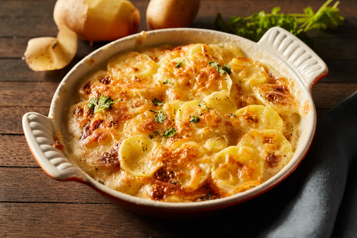 Kartoffel-Gratin in einer ovalen Auflaufform mit cremiger Sauce, überbackenem Käse und goldbraunen Kartoffelscheiben.