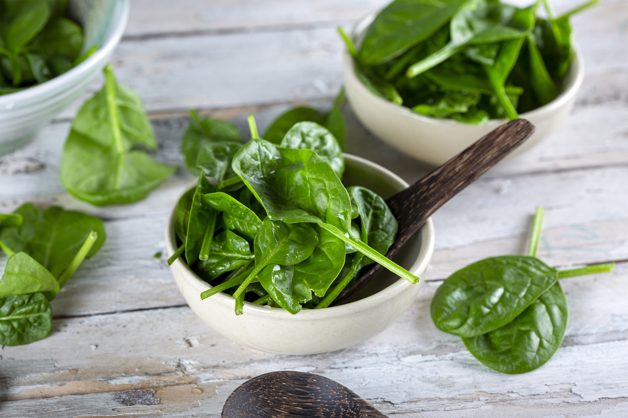 Grüne Spinatblätter in Schalen serviert, bereit zur Zubereitung von Salat oder Gemüsegerichten.