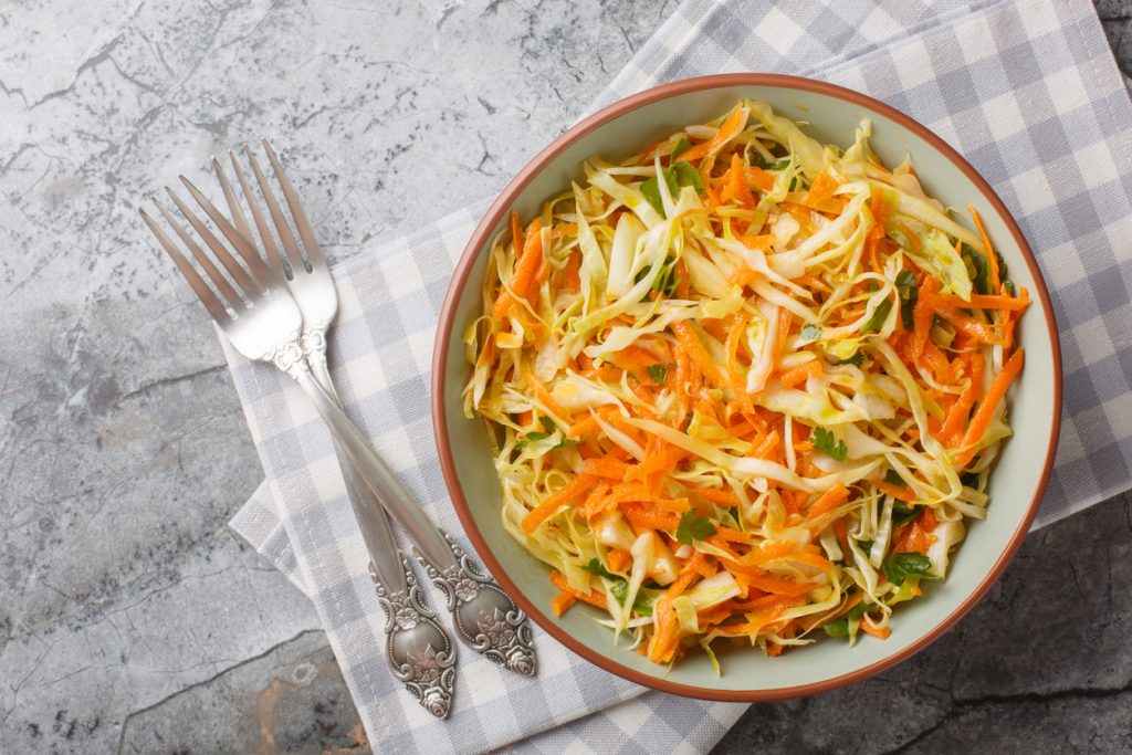 Schüssel mit Weißkohlsalat und geraspelten Karotten