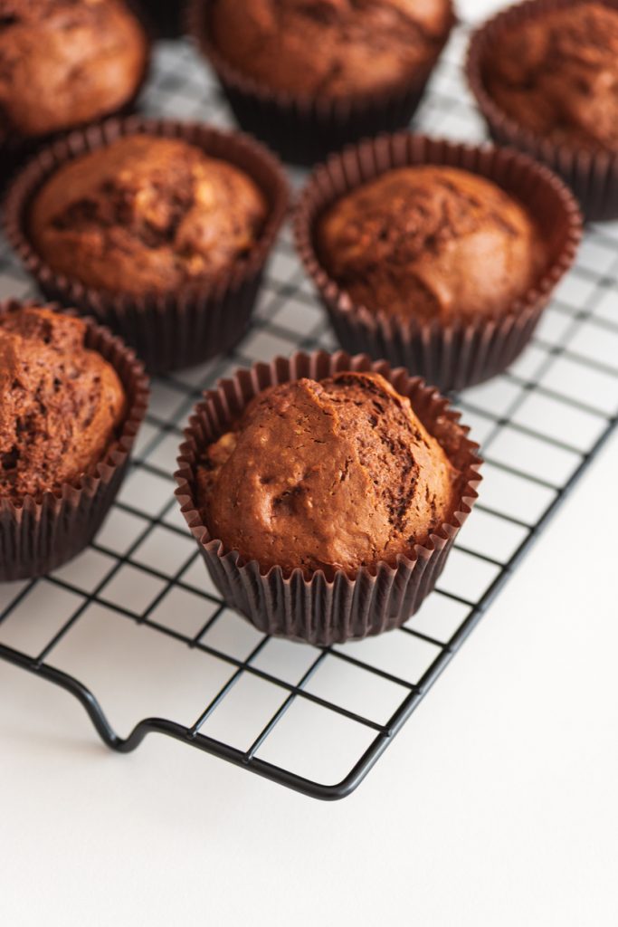 Schokoladen-Muffins in braunen Förmchen auf einem Abkühlgitter.