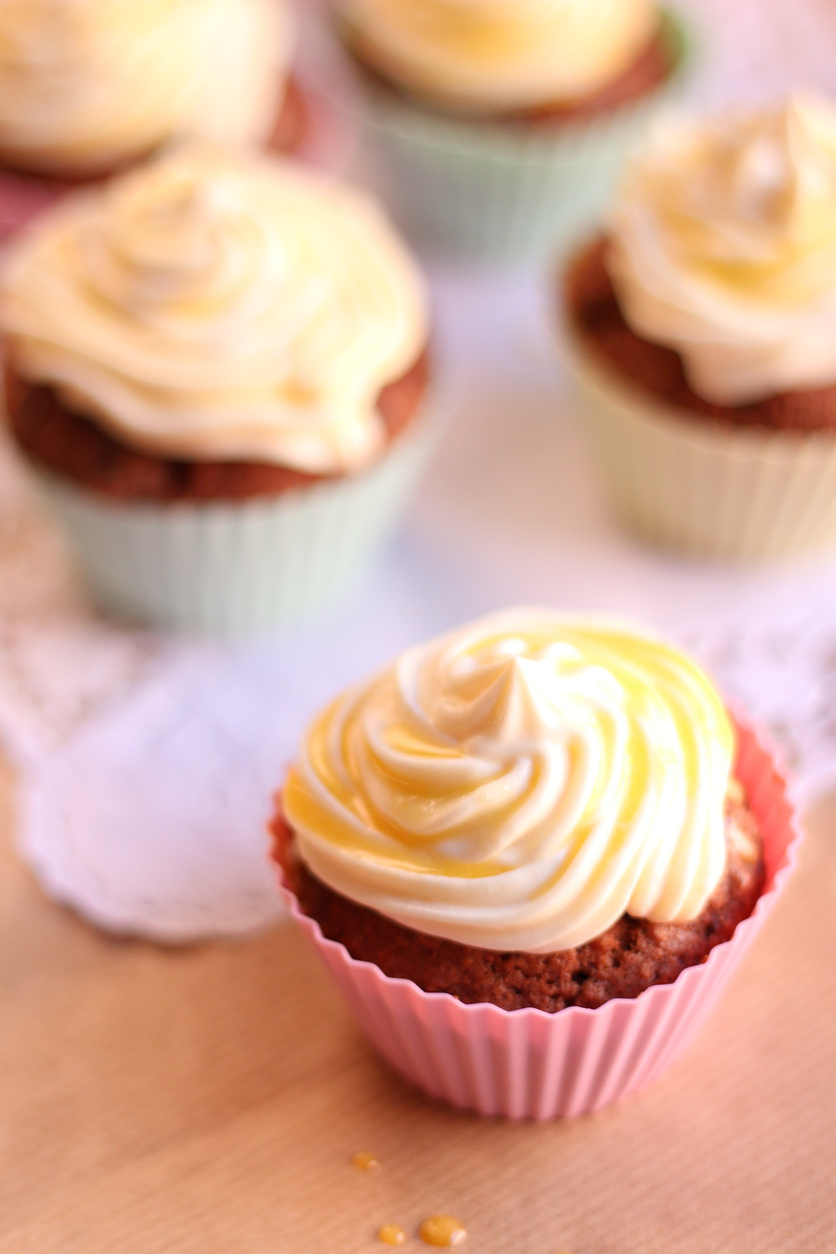 Cupcake im rosa Förmchen mit Frischkäse-Topping und Eierlikörstreifen.