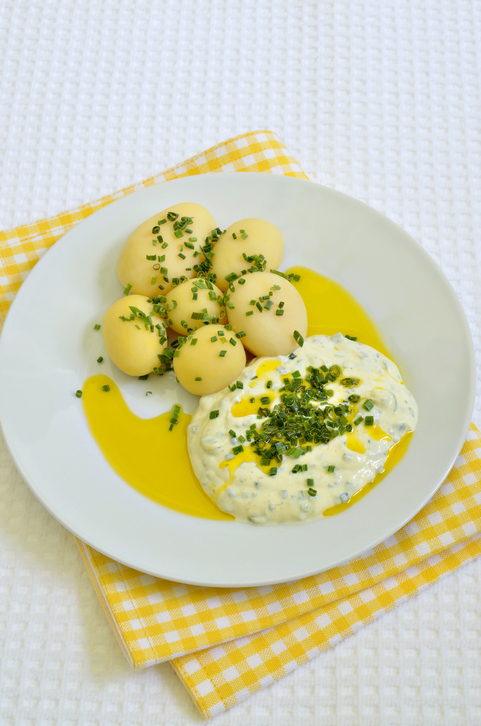 Goldgelbe Kartoffeln neben einer Portion Kräuterquark, großzügig mit Leinöl beträufelt.